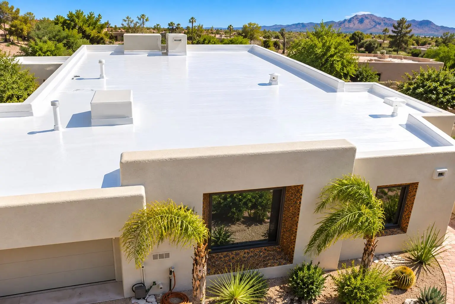White reflective coating on a flat roof with stucco parapet walls under bright Tucson sun